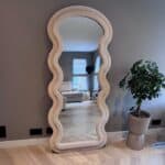 Wavey_beige1 Elegant houten muurspiegel met golvende rand, modern interieurontwerp, woondecoratie, stijlvolle woonkamer, natuurlijke houtafwerking, sfeercreatie, design spiegel, trendy interieuraccessoire, spiegel met unieke vorm, sfeer en stijl.