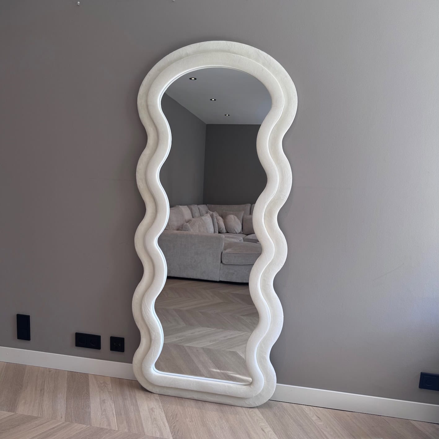 Elegant wit houten randelijk staand spiegel met sierlijke golvende rand voor modern interieurdesign.